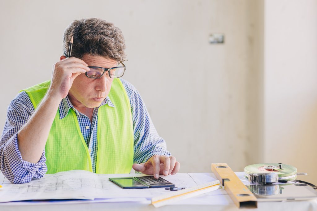 Engineer builder calculate construction bill cost feel worry for excessive project cost expenditure
